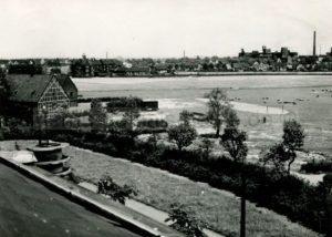 Die Hundewiese mit dem Hof Lechtape, im Hintergrund links der Wasserturm am Hauptbahnhof, rechts die Zeche Shamrock 3, 4 und 11, undatiert, Foto Stadtarchiv Herne
